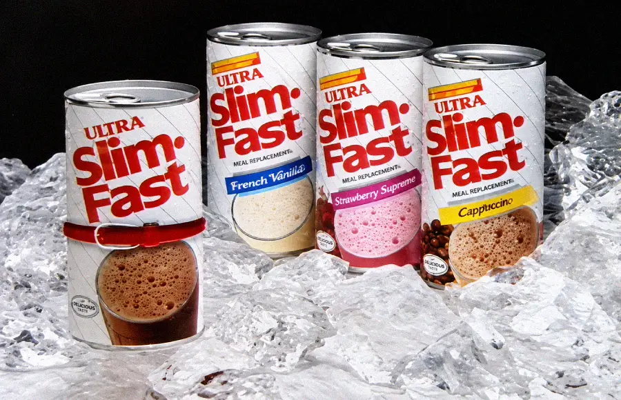 Four SlimFast meal replacement cans (French Vanilla, Strawberry Supreme, Cappuccino, and Chocolate Royale) are displayed on ice. The cans have images of the drink flavors on the labels.