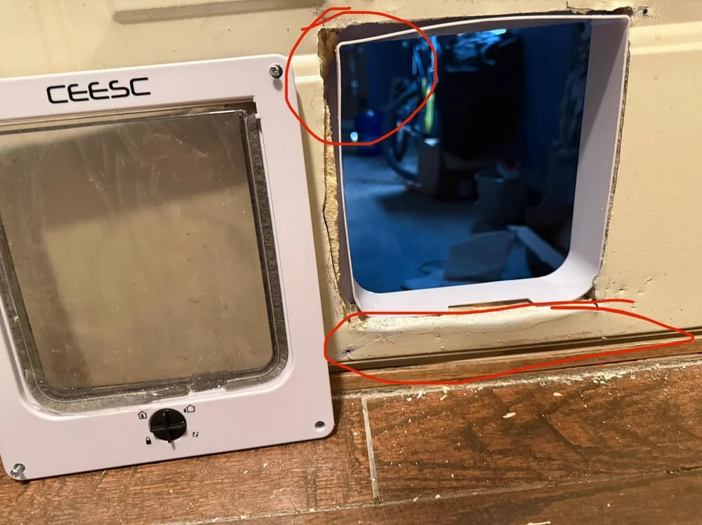 A pet door is installed incorrectly next to a rough hole in a wall. Red circles highlight misalignment and gaps. Tools and clutter are visible through the opening.