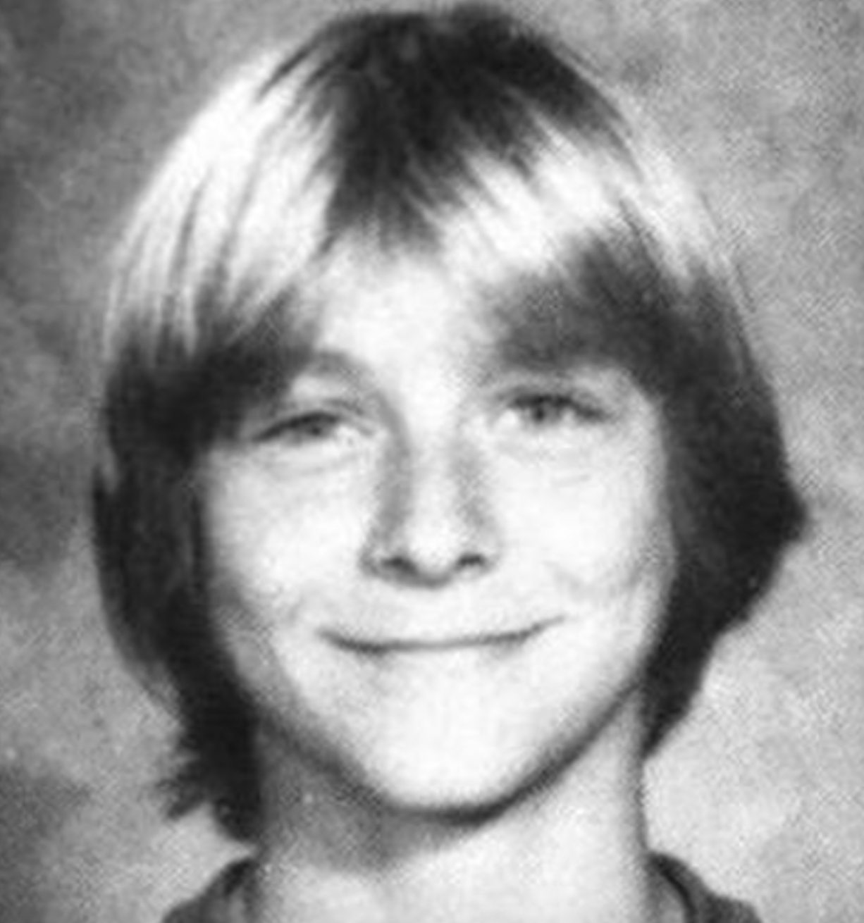Black and white yearbook-style photo of a young person with medium-length, straight, light hair, smiling at the camera.