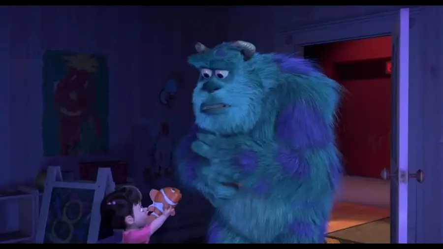 A little girl holds up a toy fish to a large, blue and purple furry monster inside a dimly lit room with a red-lit doorway in the background.