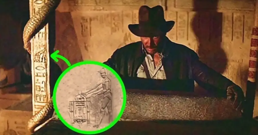 Indiana Jones stands by an ancient pillar with hieroglyphs. A green circle highlights a carving resembling Star Wars characters C-3PO and R2-D2 among the hieroglyphs.