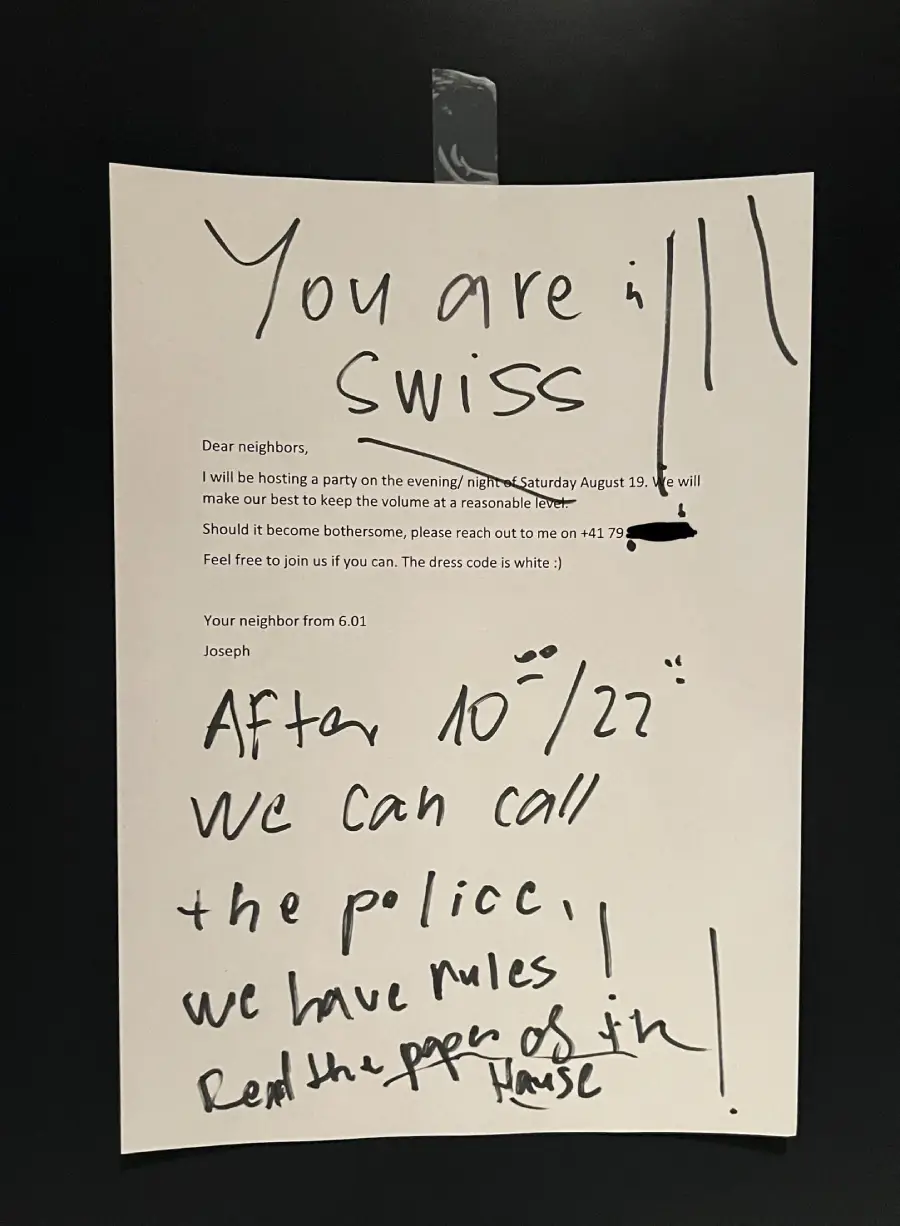 A printed party invitation is taped to a wall. Angry handwritten notes below threaten to call the police and mention rules and the “real papers of the house,” expressing frustration with the planned event.