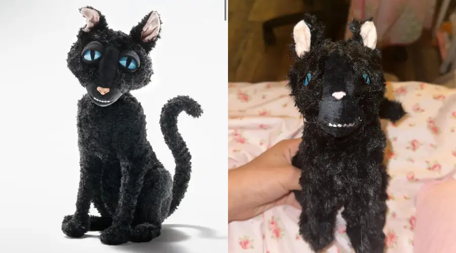 Two black cat plush toys side by side: the left one looks professionally made with blue eyes, the right one is handmade with uneven features, blue eyes, crooked ears, and visible stitching, resting on a pink patterned fabric.