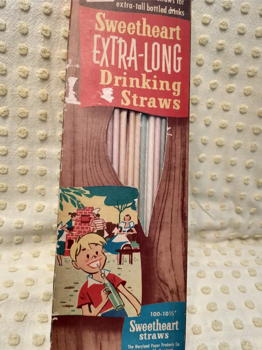 Vintage box of Sweetheart Extra-Long Drinking Straws with a cartoon boy drinking from a straw, a picnic scene, and a cutout showing the straws inside the package. Box text promotes the straws for extra-tall bottled drinks.
