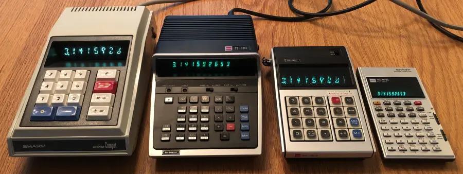 Four vintage electronic calculators with green digital displays sit side by side on a wooden surface, each showing the same number: 3141592653. All calculators have distinct button layouts.