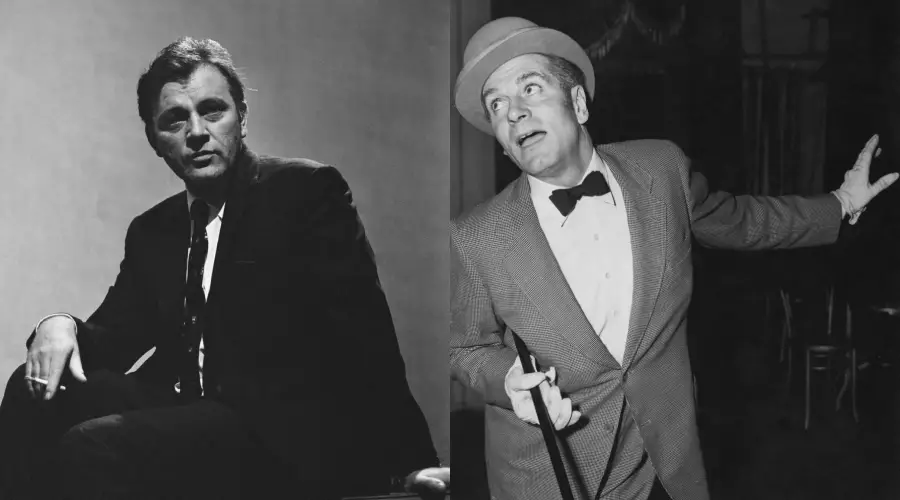 Two men in black and white. The man on the left wears a dark suit, sitting with a cigarette. The man on the right wears a suit, bowtie, and hat, holding a cane and gesturing with his left hand, looking surprised.