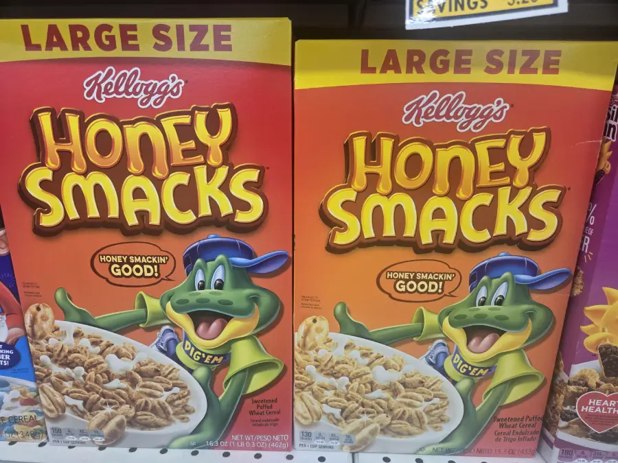 Two large boxes of Kellogg’s Honey Smacks cereal featuring a green frog mascot, Dig’em, wearing a blue cap and giving a thumbs up. The box says “Honey Smackin’ Good!” and shows a bowl of cereal.