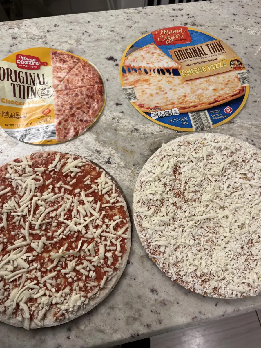 Two frozen cheese pizzas on a kitchen counter, each next to its packaging. One pizza has more cheese coverage than the other. Both packages are labeled “Original Thin Cheese Pizza.”