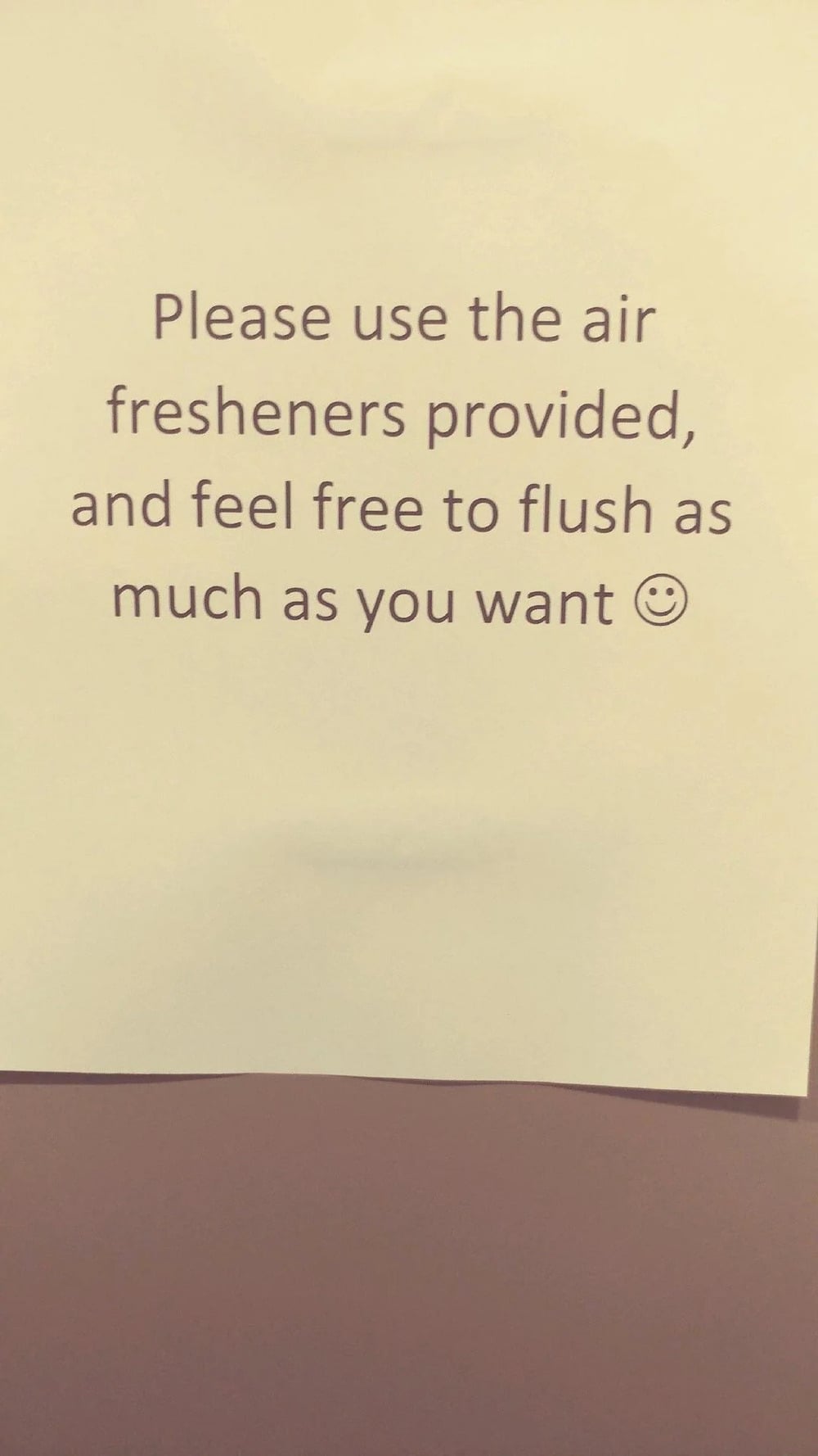 A sign reads: “Please use the air fresheners provided, and feel free to flush as much as you want :)”