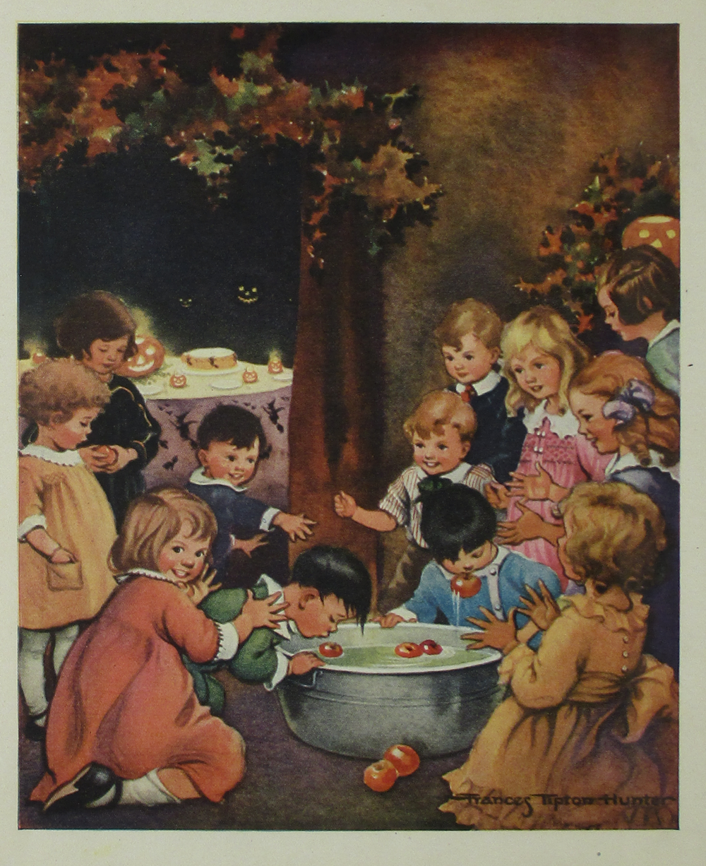 A group of children gathered around a metal tub bobbing for apples at a Halloween party.