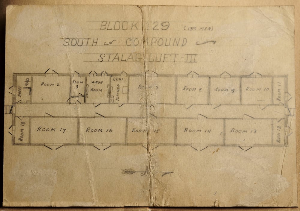 Hand-drawn floor plan of Block 129 in the South Compound of Stalag Luft III, showing an 18-room layout with labeled wash, coal, and kitchen areas.