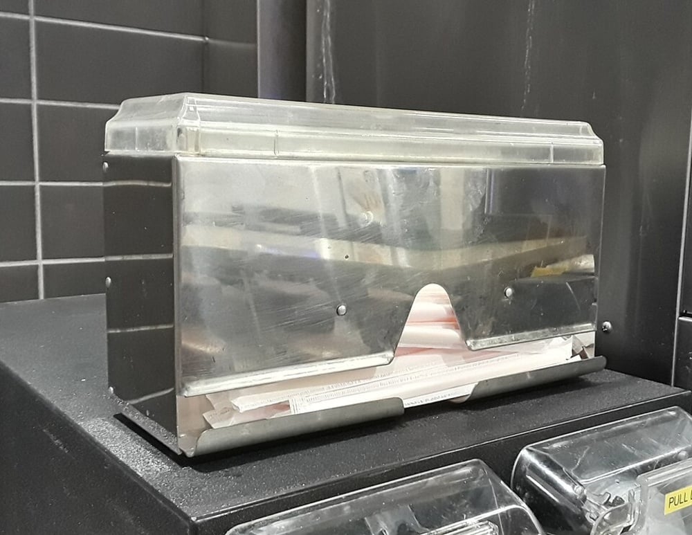 A metal straw dispenser with a clear plastic lid.