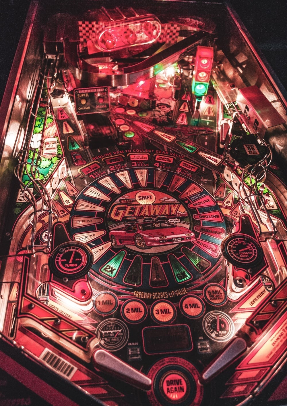 The Getaway pinball machine playfield featuring a red sports car graphic, glowing gauges, and ramps.