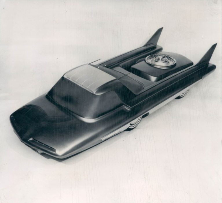 A futuristic concept car model with large tail fins and a spare tire mounted on the rear deck.