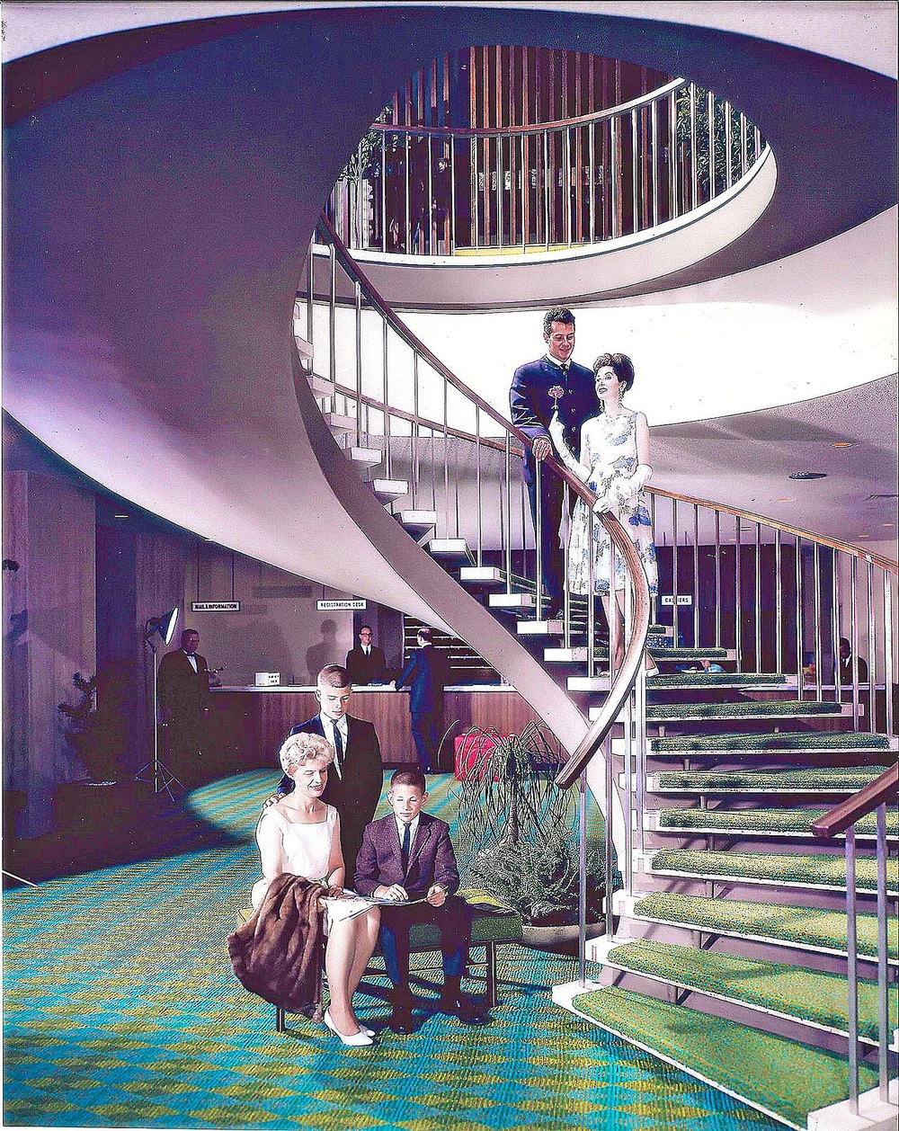 A family posing in a hotel lobby with a grand, curved staircase and green patterned carpet.