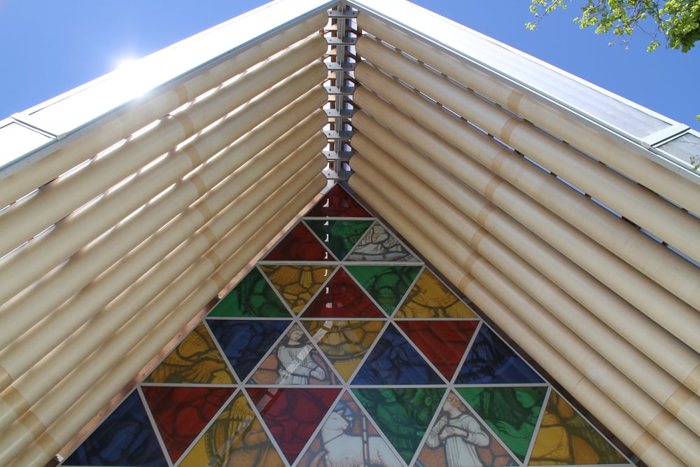 A triangular stained-glass window set into the gabled roof structure of the Cardboard Cathedral.