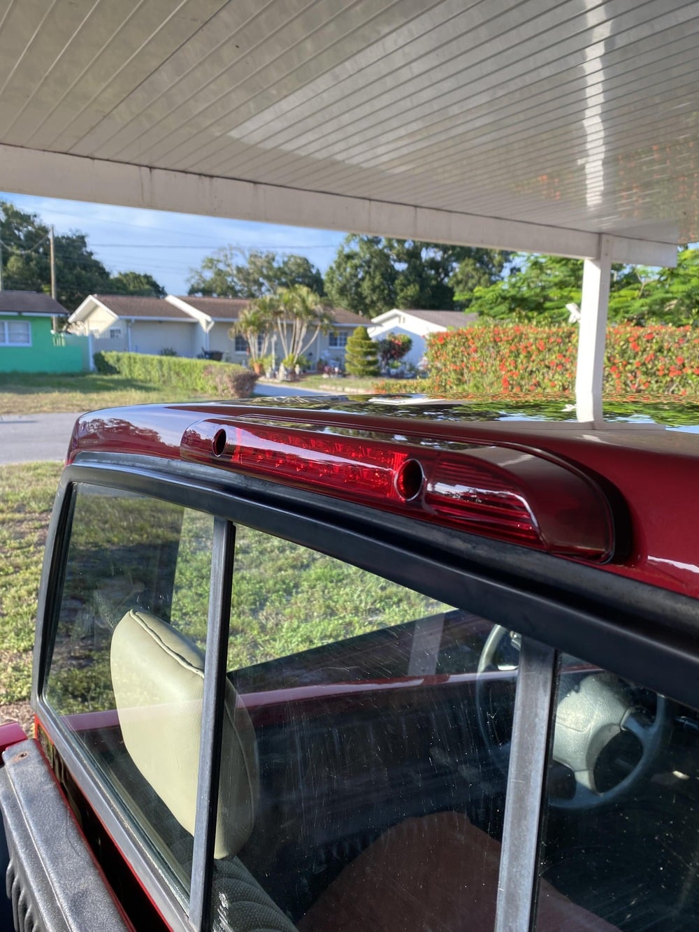 A red truck’s high-mount brake light installed above the rear sliding window.