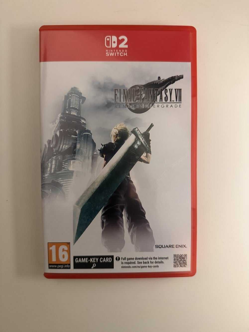 Nintendo Switch case for “Final Fantasy VII Remake Intergrade,” featuring Cloud Strife holding a large sword with a sci-fi city background. PEGI 16 rating and game card symbols are visible.