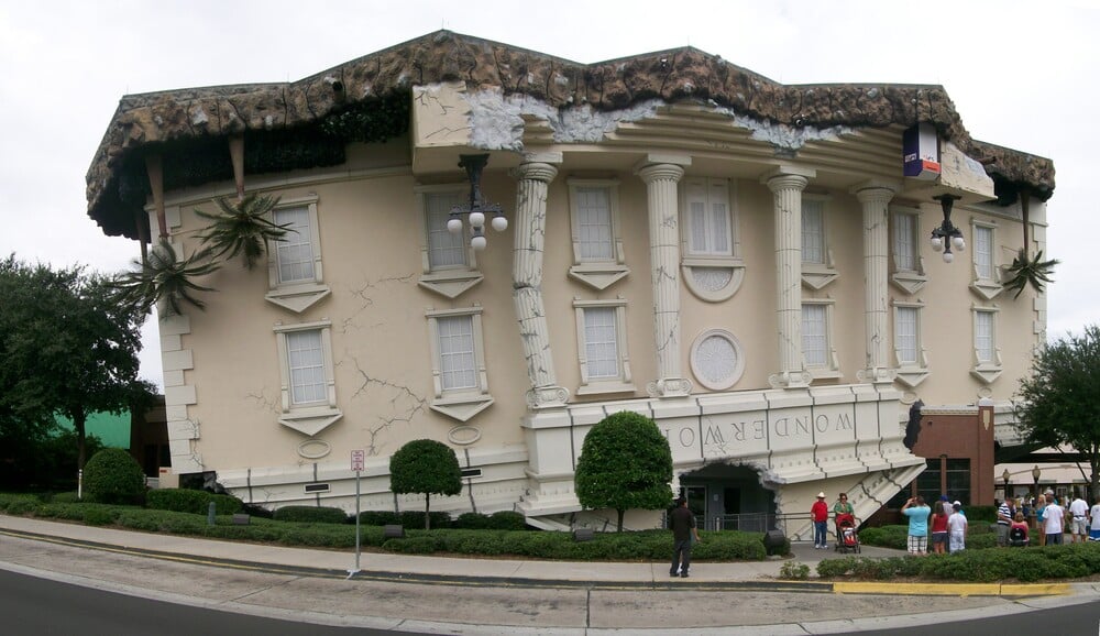 A building designed to look like it has fallen upside down, with its foundation exposed at the top and the entrance at ground level.
