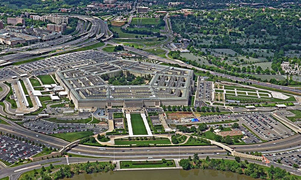 Aerial view of the Pentagon building in Arlington, Virginia, surrounded by parking lots, highways, and a cemetery.