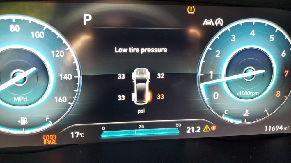 Car dashboard display showing a low tire pressure warning for the rear-right tire, with current psi readings for all four tires.