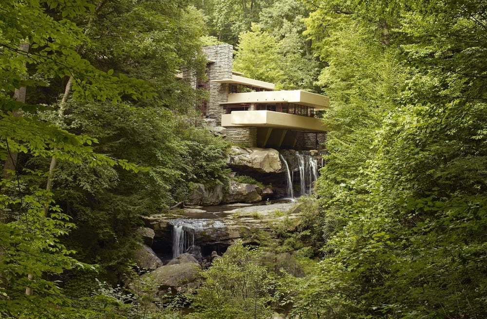 Fallingwater, a house designed with horizontal concrete terraces, built directly over a small waterfall in a dense forest.