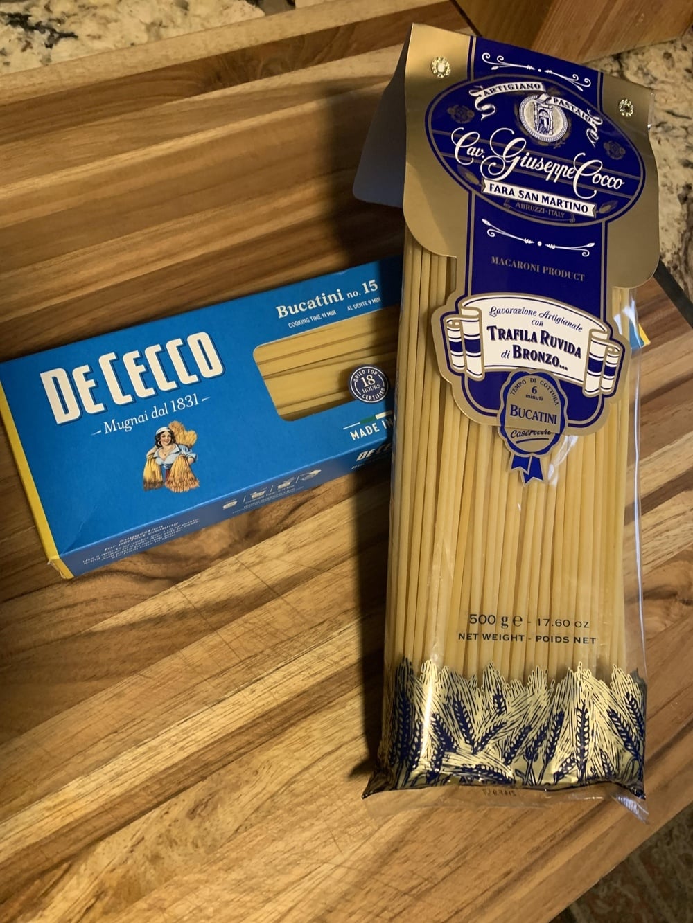 A box of De Cecco bucatini pasta next to a package of Cav. Giuseppe Cocco long pasta.