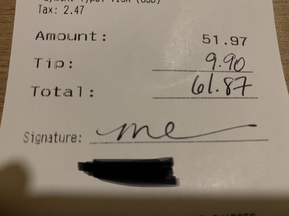 Restaurant receipt with a handwritten tip of 9.90, a total of 61.87, and a signature.