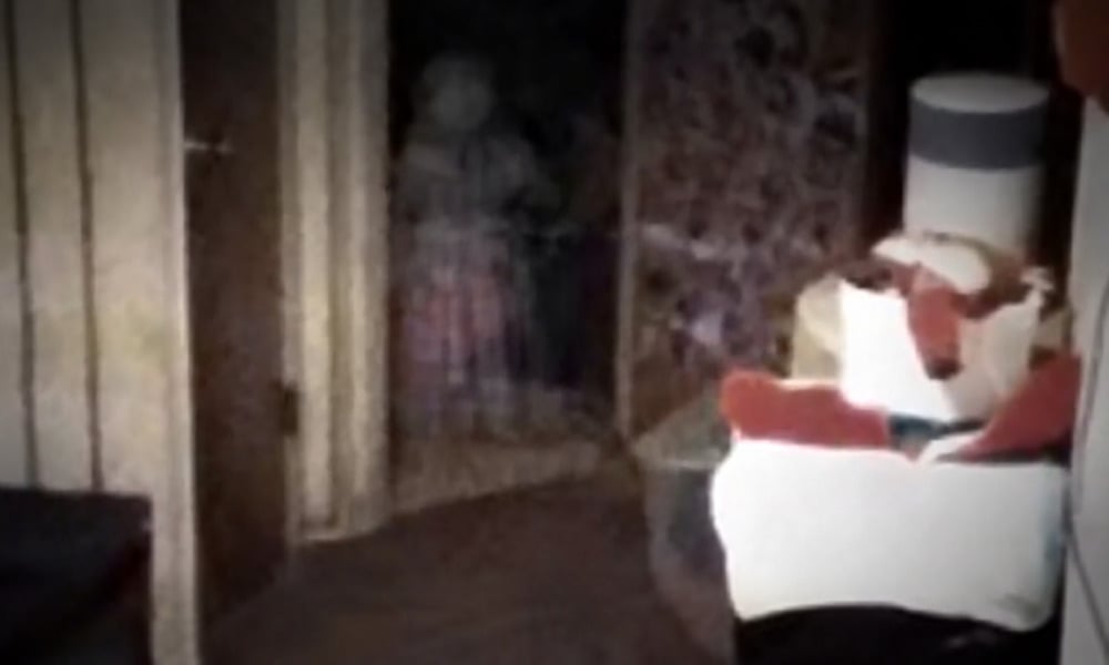 A blurry, translucent figure standing in a doorway at the end of a dark hallway.