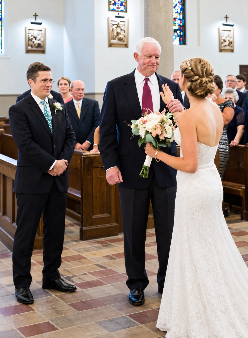 A bride in a white wedding gown holding a bouquet waves to a man in a suit, while a groom stands nearby at the altar of a church.