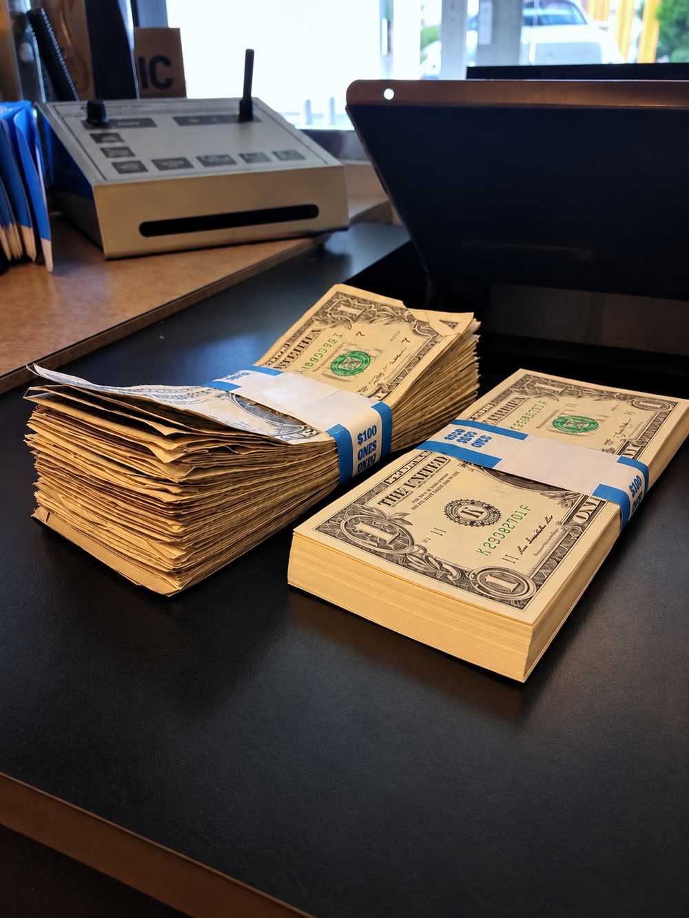Stacks of crisp and heavily circulated one-dollar bills side by side.