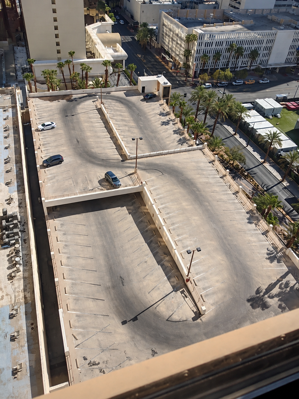 An aerial view of a parking garage with tire paths darkened into curves.