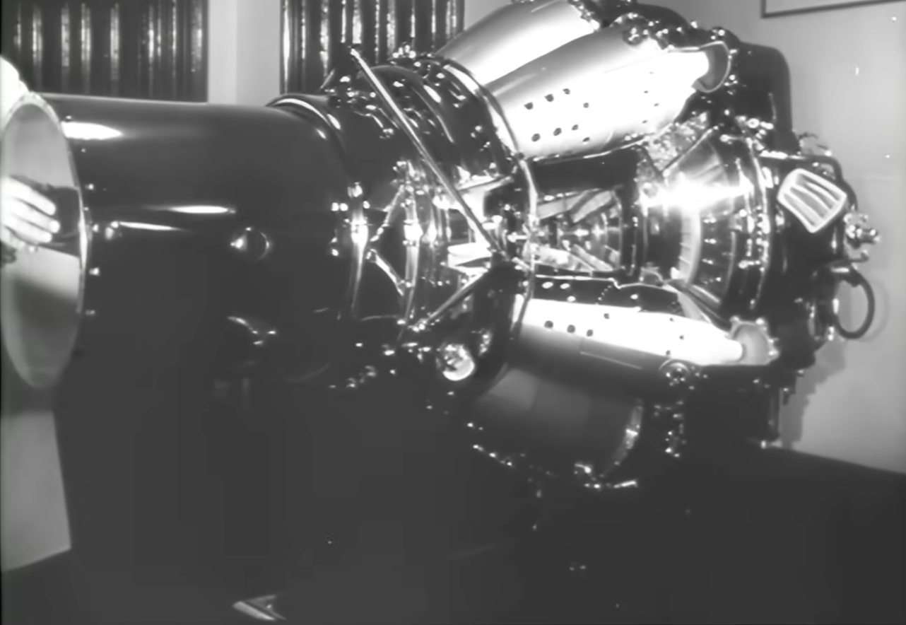 A person’s hands hold the opening of a large, complex jet engine assembly.