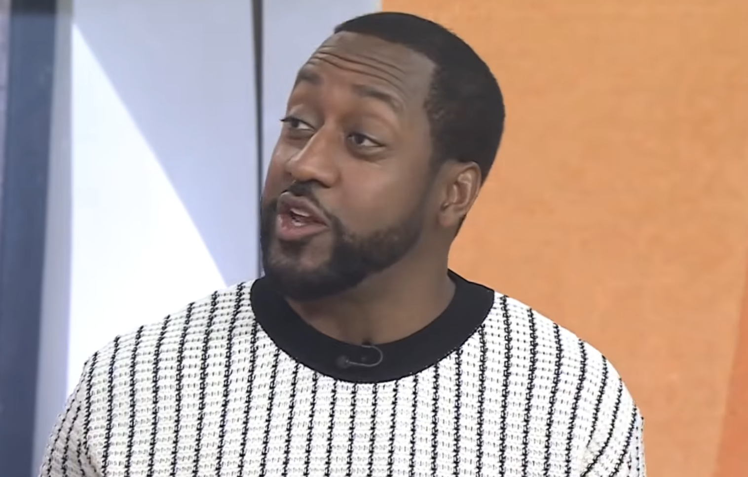 Jaleel White wearing a black and white striped sweater with a black collar.