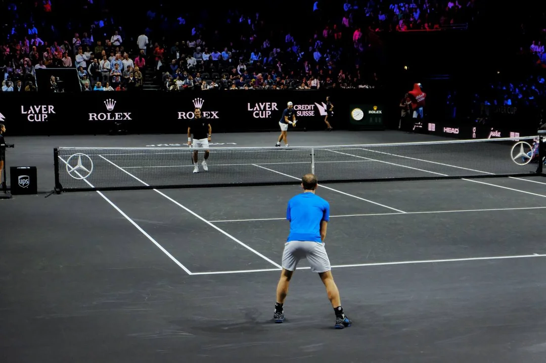 Two tennis players on a dark court at the Laver Cup during a match.