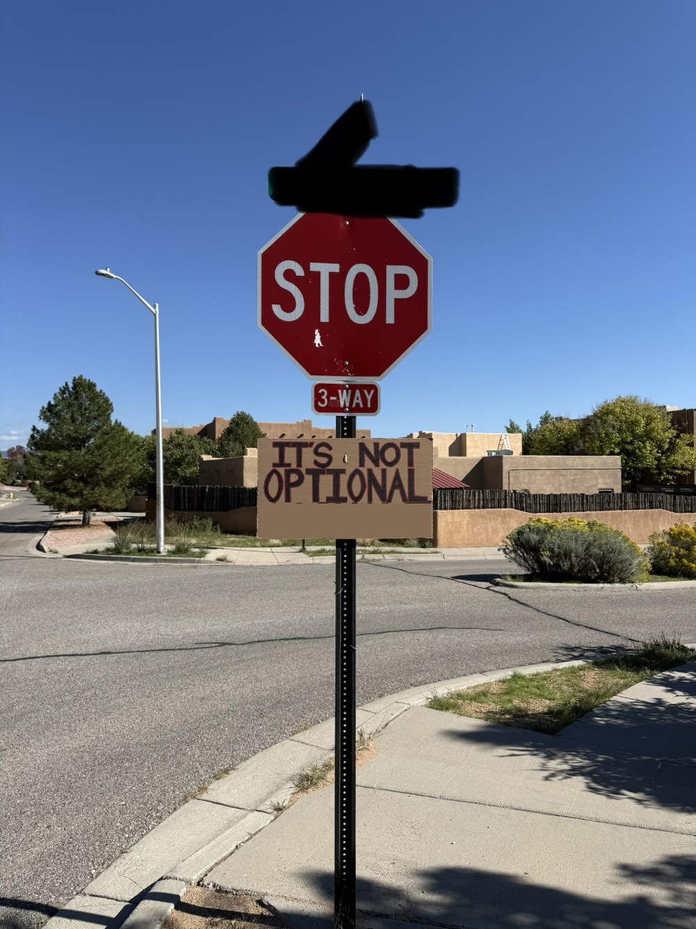 A stop sign with a secondary sign attached that reads, “IT’S NOT OPTIONAL.”