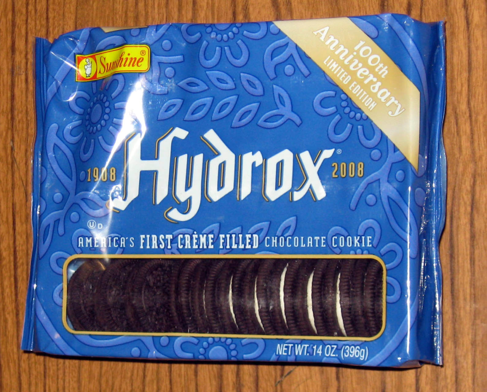 A package of Hydrox sandwich cookies commemorating their 100th anniversary, showing a row of dark chocolate cookies with cream filling through a clear window.