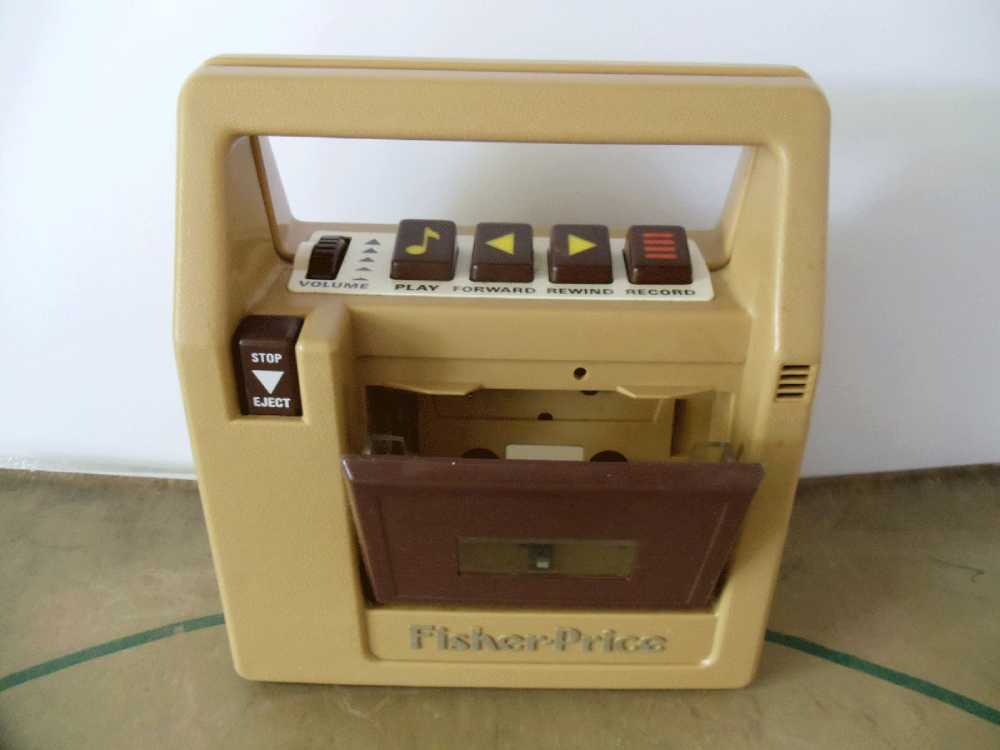 Vintage Fisher-Price toy cassette player in tan and brown with volume, play, forward, rewind, record, and eject buttons.