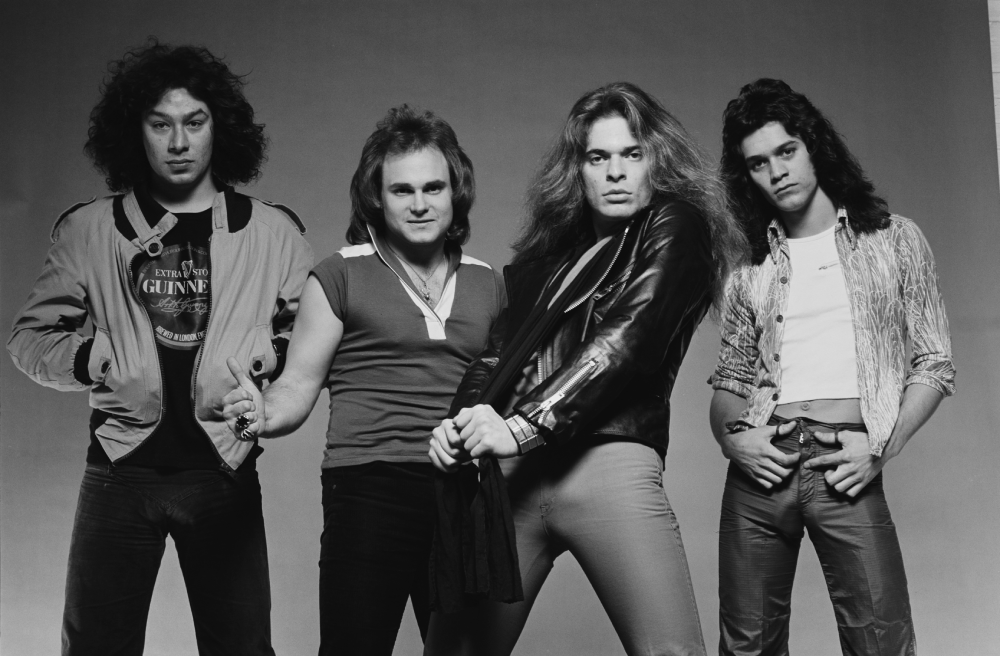 Black and white studio portrait of the rock band Van Halen standing side-by-side.