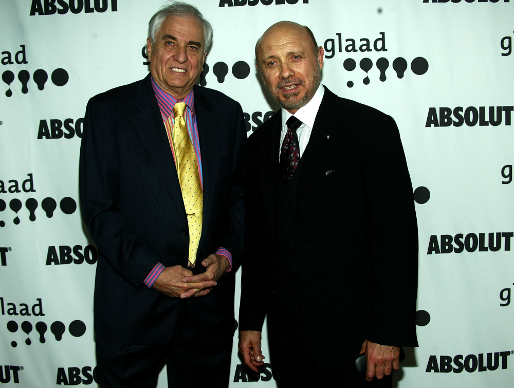 Two men in suits stand in front of a step-and-repeat backdrop featuring the GLAAD and Absolut logos.