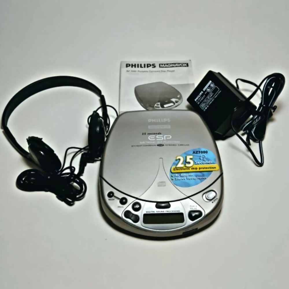 Philips Magnavox portable CD player with headphones, AC adapter, and user manual.