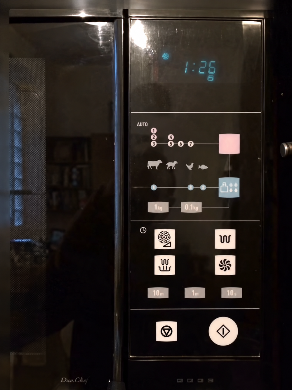 Black microwave control panel with a digital clock displaying 1:26, auto-cook icons for meat and fish, weight settings, and various function buttons.