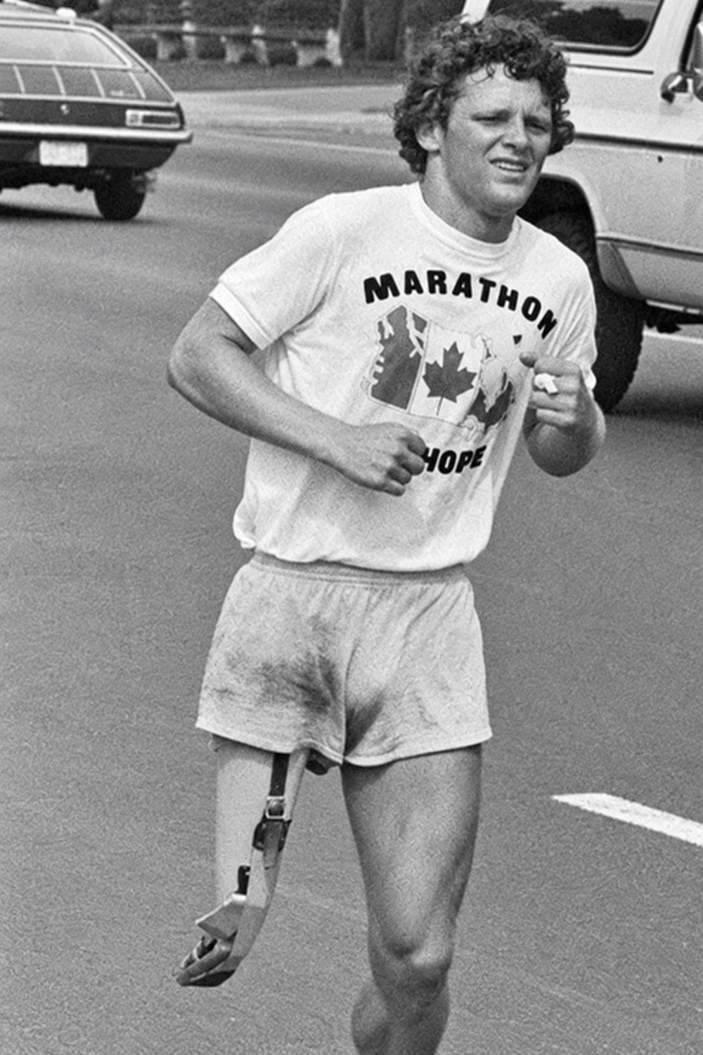 Terry Fox running in a Marathon of Hope t-shirt, wearing a prosthetic leg.