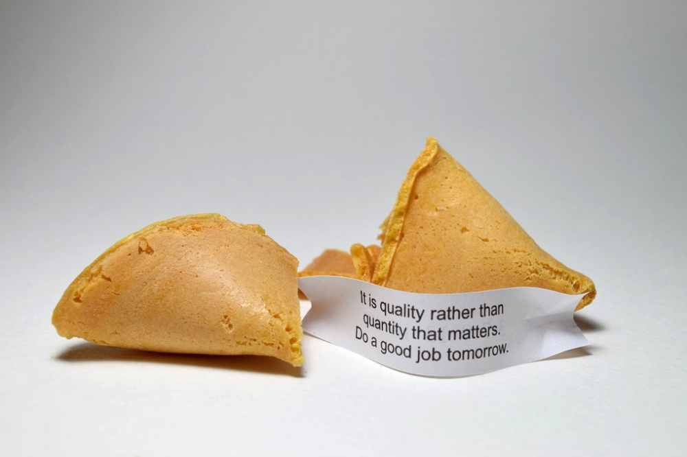 A broken fortune cookie with a paper slip reading, “It is quality rather than quantity that matters. Do a good job tomorrow.”