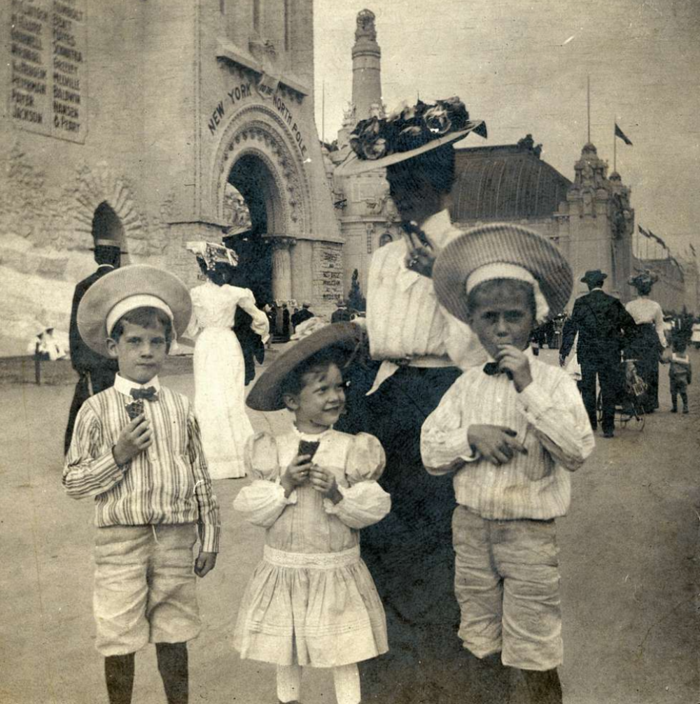 Three children eating ice cream in front of the New York to the North Pole exhibit at the 1904 St. Louis World’s Fair.