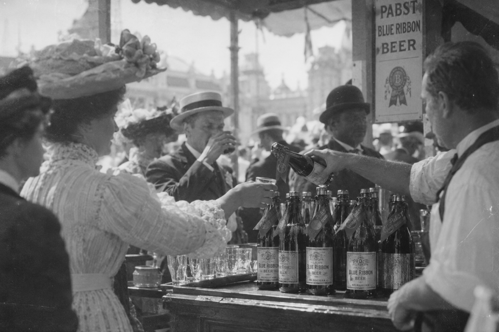 A bartender pours a bottle of Pabst Blue Ribbon beer into a glass for a woman at an outdoor fair.