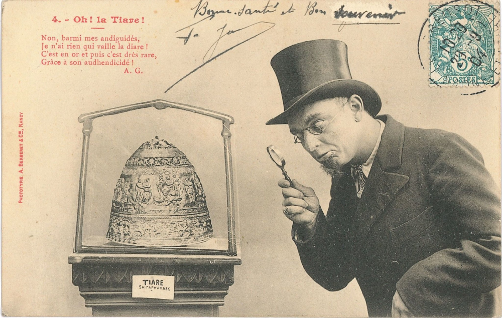 A man in a top hat and glasses examines a golden tiara under a glass display case in this vintage postcard featuring French text and a postage stamp.