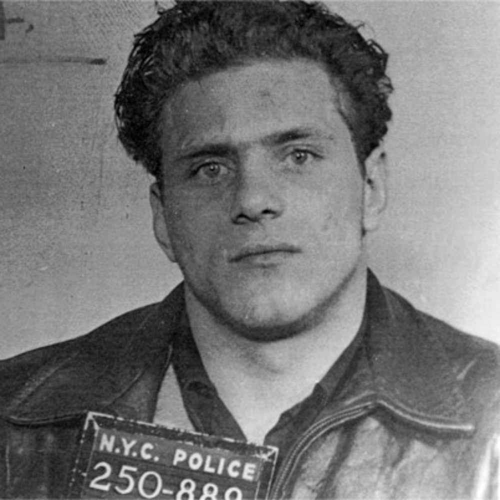 Black and white police mugshot of a man holding a sign that reads “N.Y.C. Police 250-880.”