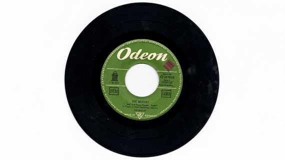 A black 45 RPM vinyl record by The Beatles on the Odeon label, featuring the songs “Twist and Shout” and “There’s a Place.”