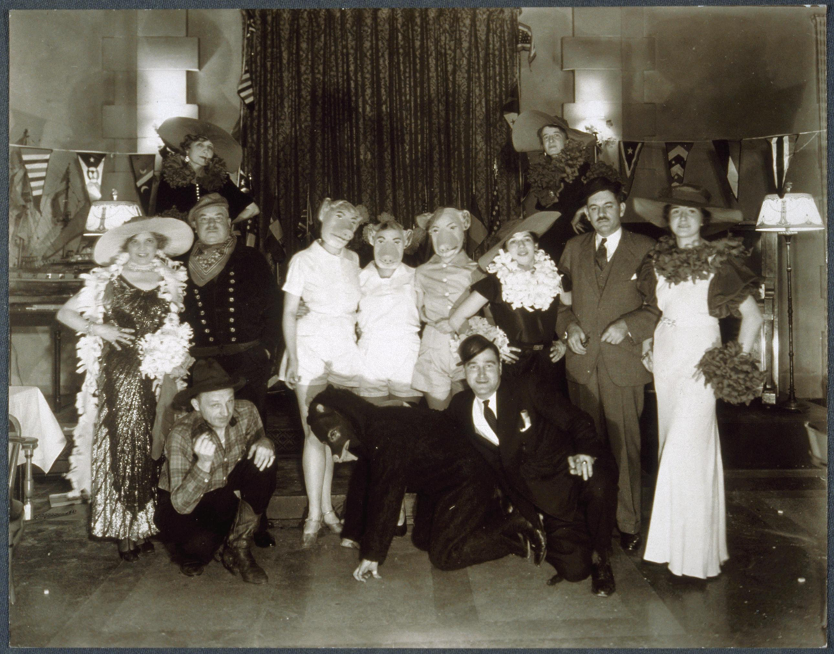 A group of adults at a costume party, with several wearing animal masks and one person dressed as a horse.